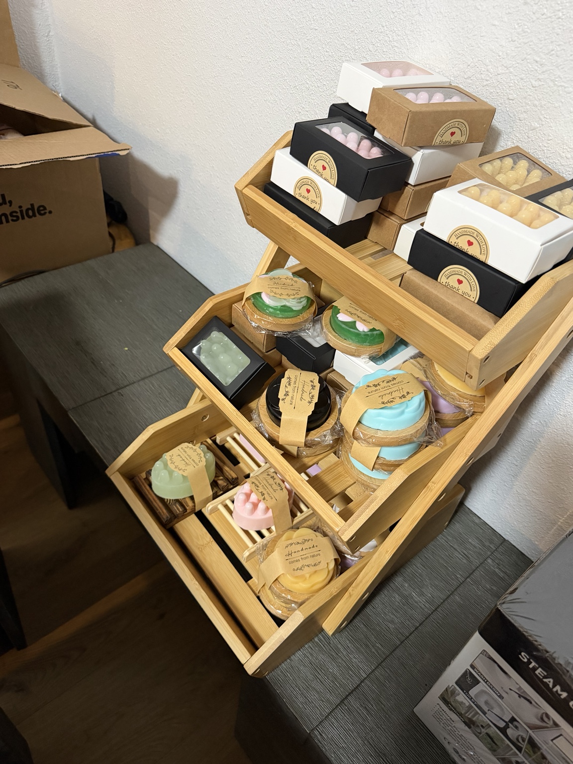 Sud Buds handmade soaps packaged and displayed on bamboo shelves